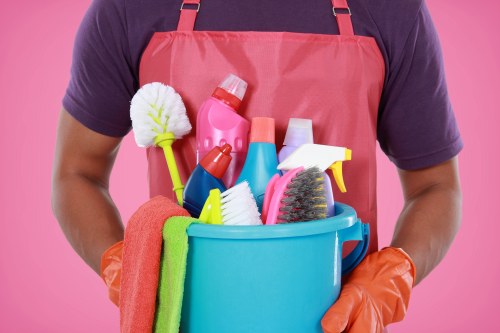 Trained cleaner in Wandsworth using protective gloves and cleaning supplies